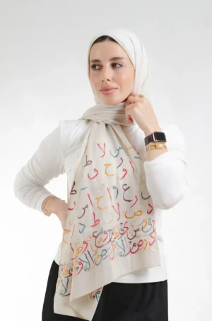 The Ahrof Beige Arabic Letters Tatreez Shawl is a soft, breathable embroidered hijab made from crepe fabric with delicate detailing—ideal for daily wear and special occasions.