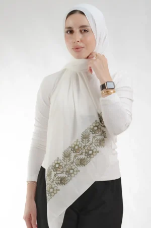 The Pine Eggshell Tatreez Shawl is a soft, breathable embroidered hijab made from crepe fabric with delicate detailing—ideal for daily wear and special occasions.