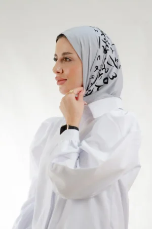 The Printed Grey Arabic Letters Triangle Shawl is a plush, feather-light embroidered hijab made from qotton fabric with elegant accents—perfect for daily wear and elegant outings.