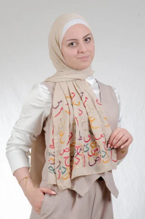 The Ahrof Beige Arabic Letters Tatreez Shawl is a soft, breathable embroidered hijab made from crepe fabric with delicate detailing—ideal for daily wear and special occasions.
