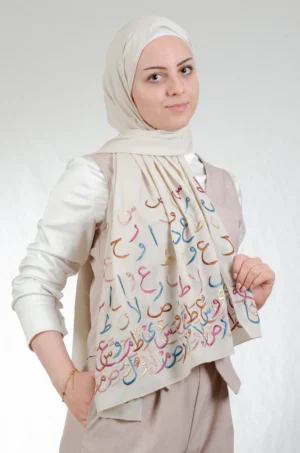 The Ahrof Dark Beige Arabic Letters Tatreez Shawl is a silky, fresh embroidered hijab made from crepe fabric with delicate stitching—excellent for regular use and dressy affairs.