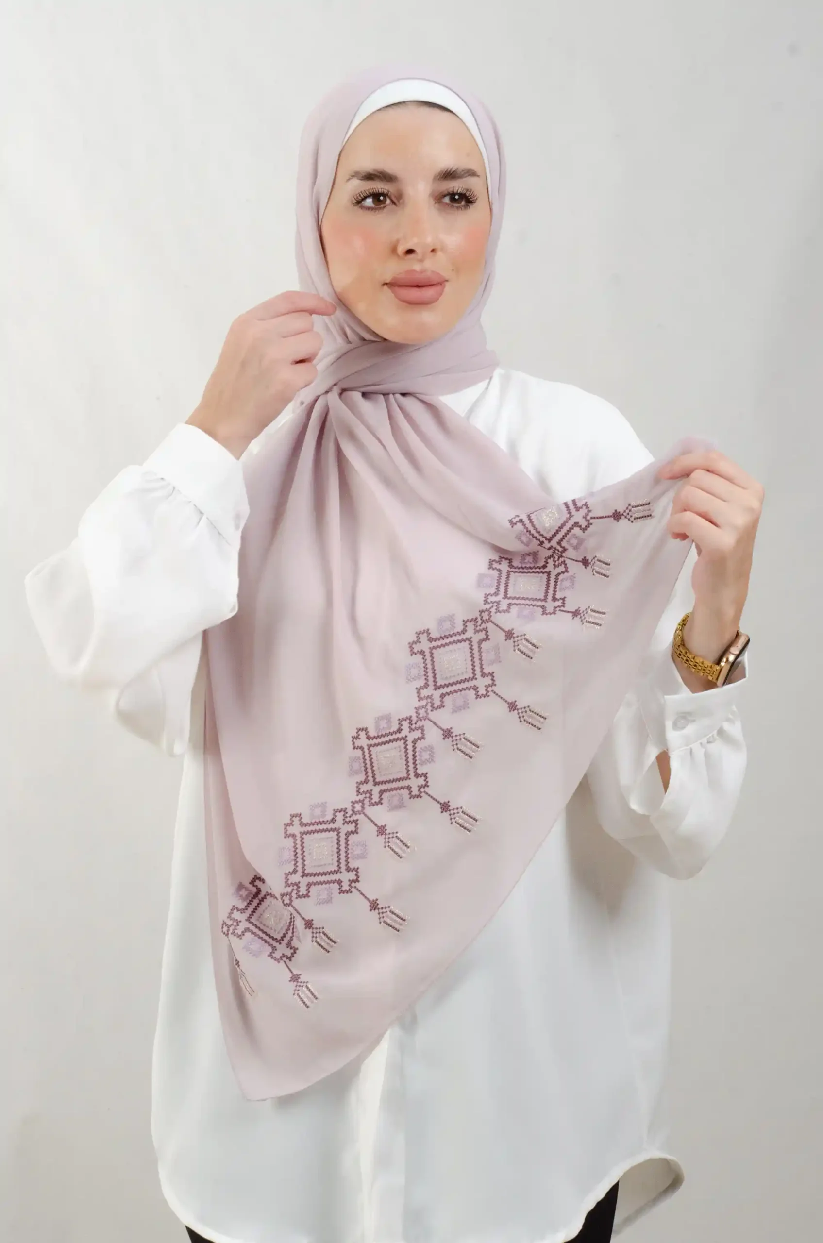 The Chandeliers Purple Tatreez Shawl is a cozy, breathable embroidered hijab made from Georgette chiffon fabric. Perfect for everyday wear and celebrations.