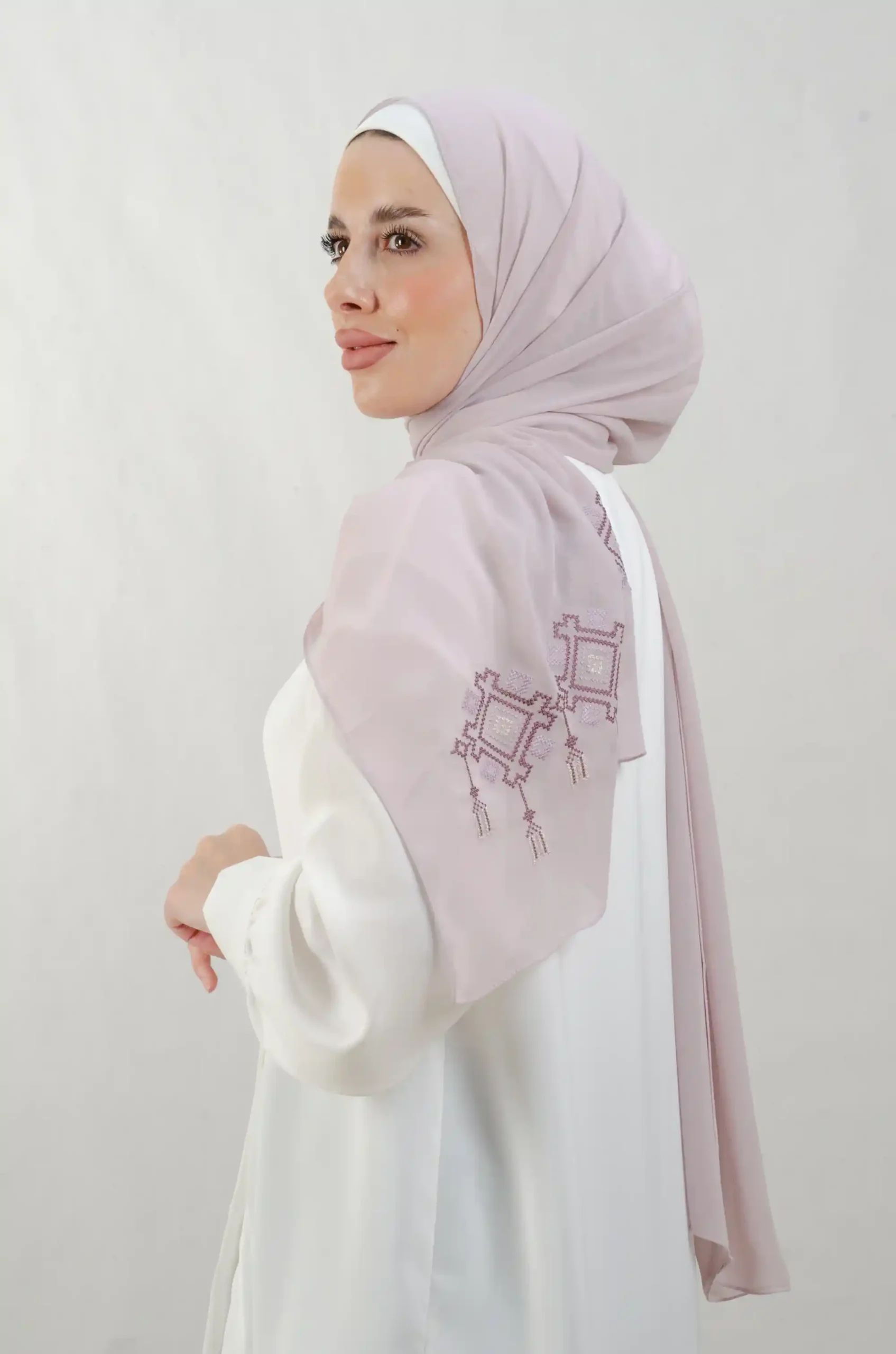 The Chandeliers Purple Tatreez Shawl is a cozy, breathable embroidered hijab made from Georgette chiffon fabric. Perfect for everyday wear and celebrations.