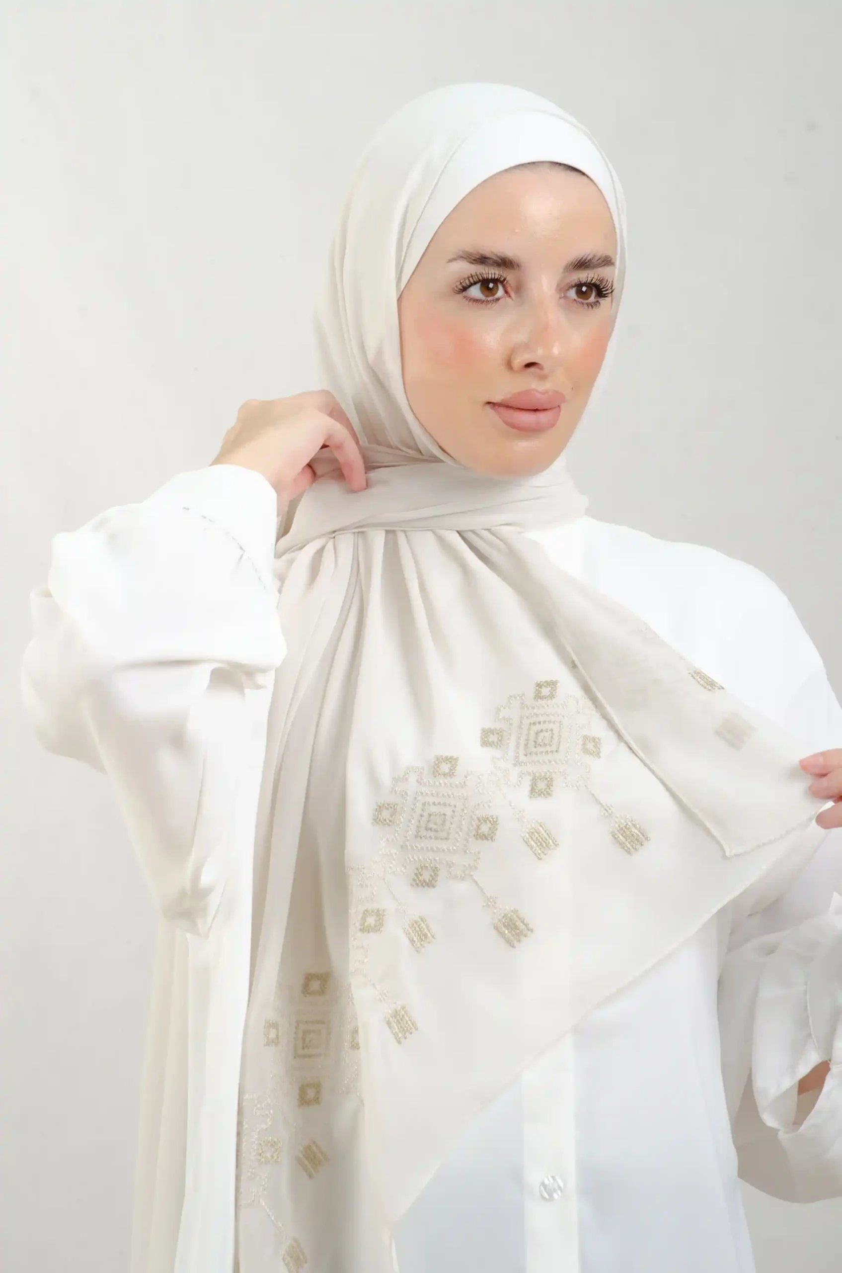 The Chandeliers Metal Tatreez Shawl is a cozy, breathable embroidered hijab made from Georgette chiffon fabric. Perfect for everyday wear and celebrations.