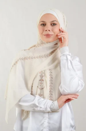 The Cypress Vine Beige Tatreez Shawl is a cozy and breathable embroidered hijab crafted from premium Georgette chiffon fabric. Designed with elegant Tatreez embroidery in Cypress Vine Beige, it offers a graceful drape and lightweight comfort. Perfect for daily wear as well as festive gatherings and celebrations. شال تطريز بيج اغصان السرو من فلاحي هاوس أغصان السرو باللون البيج هو حجاب مطرز ومريح وجيد التهوية مصنوع من قماش الشيفون جورجيت. يتميز بتطريز أنيق من أغصان السرو باللون البيج، ويوفر انسيابية أنيقة وراحة خفيفة الوزن. مثالي للارتداء اليومي بالإضافة إلى التجمعات والاحتفالات.