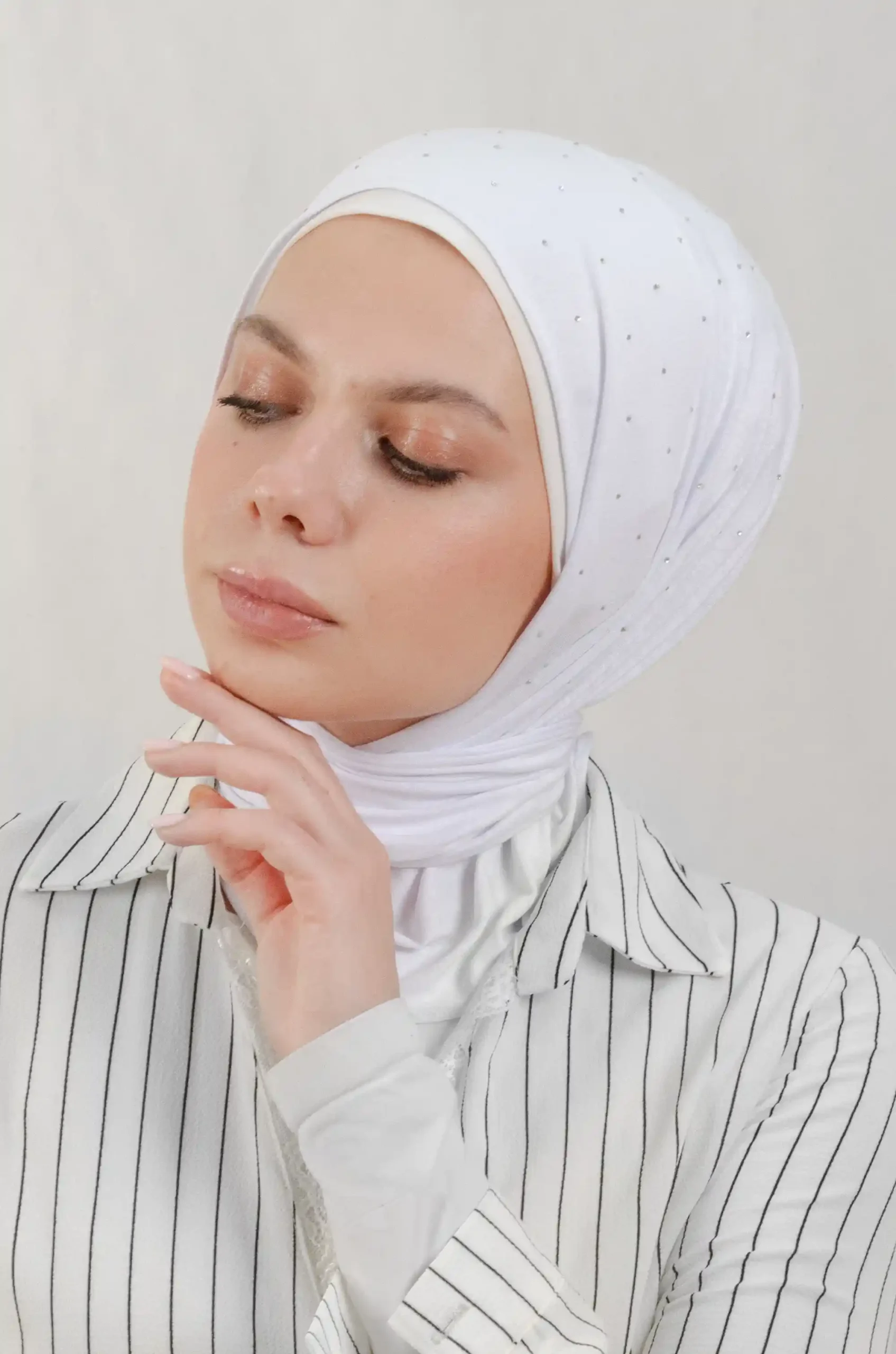 The DMC Strass Vine Beige Triangle Shawl is a cozy, breathable triangle hijab made from cotton fabric with shimmering Strass details in beige. Perfect for both daily wear and special occasions.
