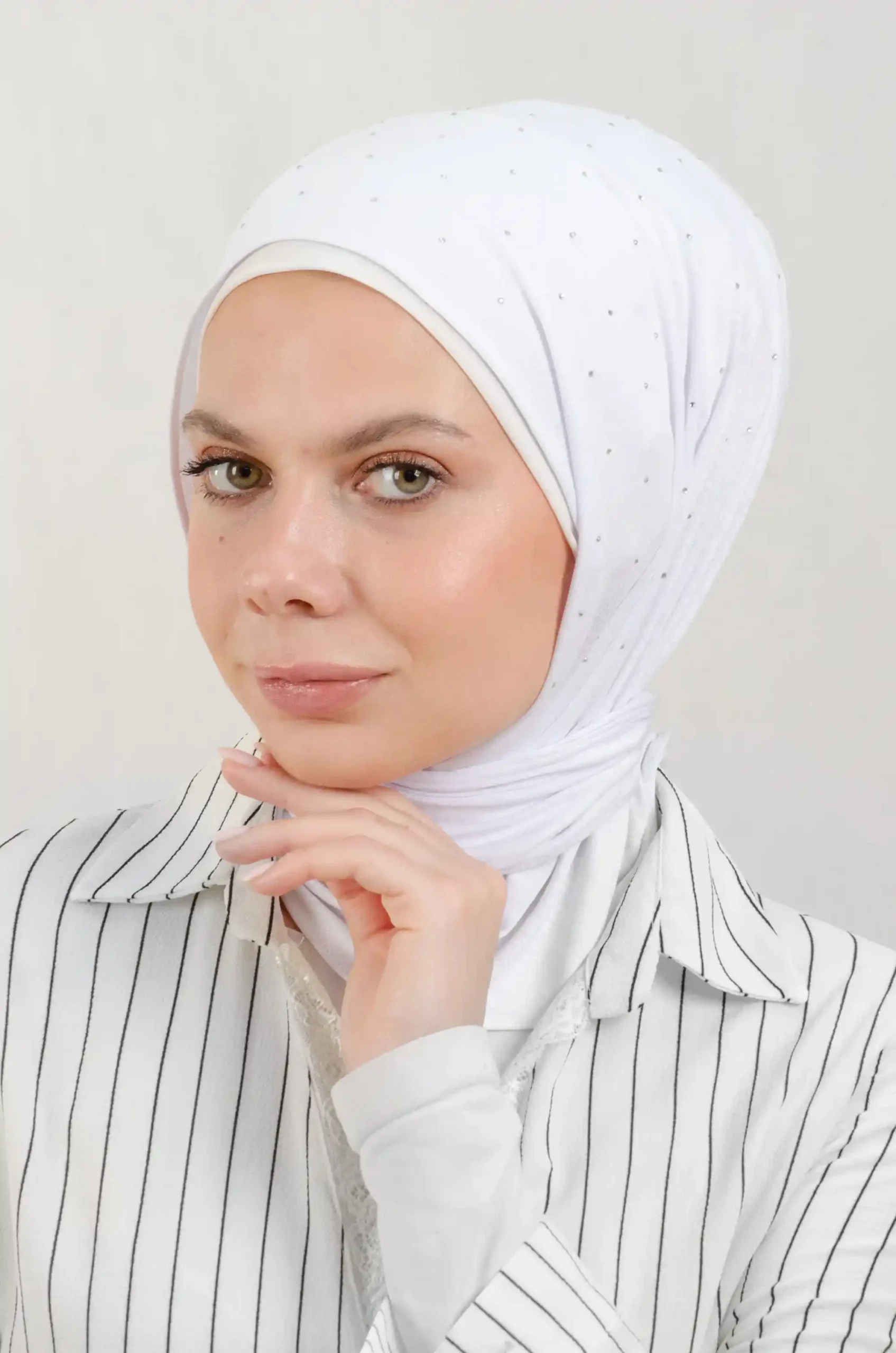 The DMC Strass Dots White Triangle Shawl is a cozy, breathable triangle hijab made from cotton fabric with shimmering Strass details in white. Perfect for both daily wear and special occasions.