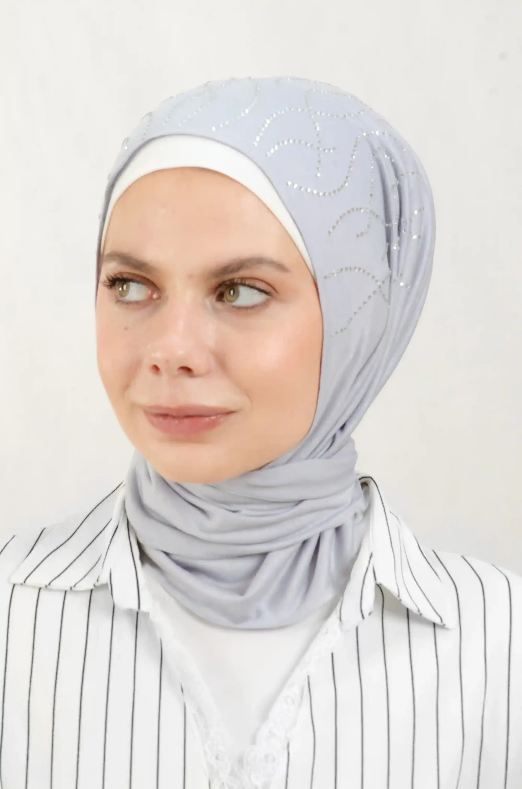 The DMC Strass Vine Grey Triangle Shawl is a cozy, breathable triangle hijab made from cotton fabric with shimmering Strass details in grey. Perfect for both daily wear and special occasions.