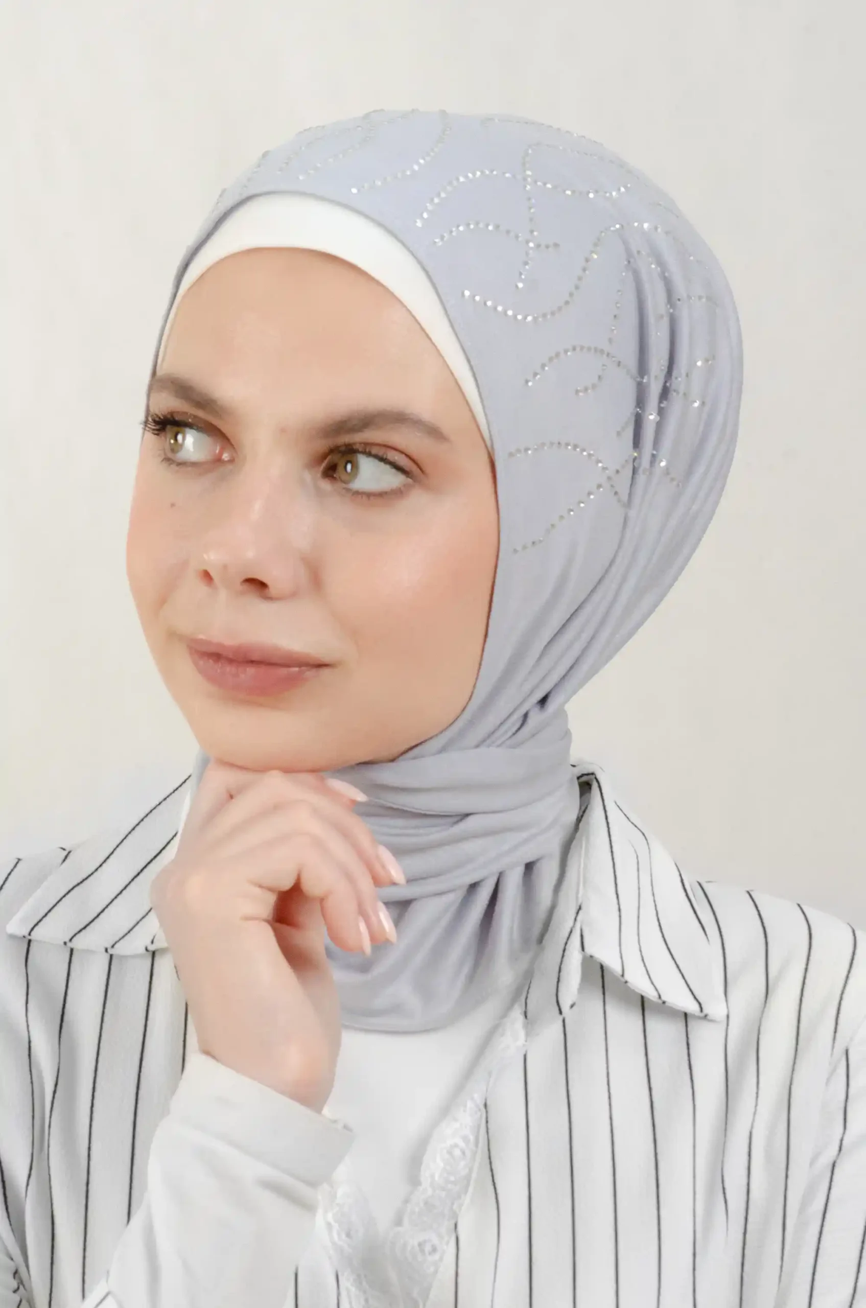The DMC Strass Vine Grey Triangle Shawl is a cozy, breathable triangle hijab made from cotton fabric with shimmering Strass details in grey. Perfect for both daily wear and special occasions.
