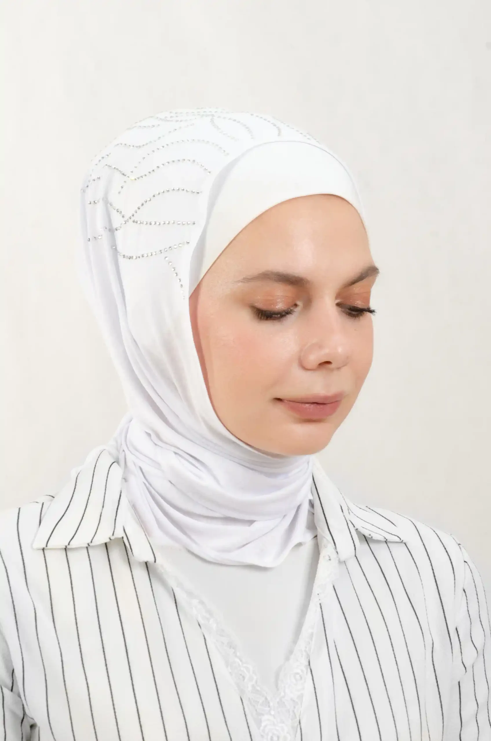 The DMC Strass Vine White Triangle Shawl is a cozy, breathable triangle hijab made from cotton fabric with shimmering Strass details in white. Perfect for both daily wear and special occasions.