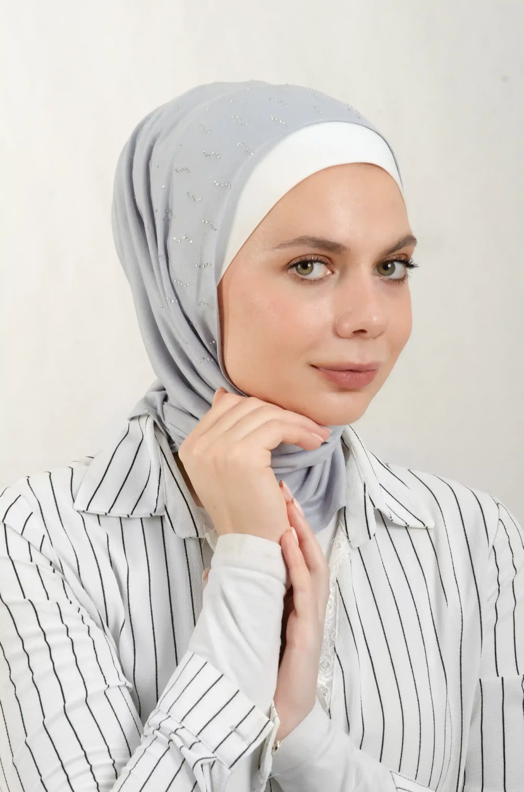 The DMC Strass Larva Grey Triangle Shawl is a cozy, breathable triangle hijab made from cotton fabric with shimmering Strass details in grey. Perfect for both daily wear and special occasions.
