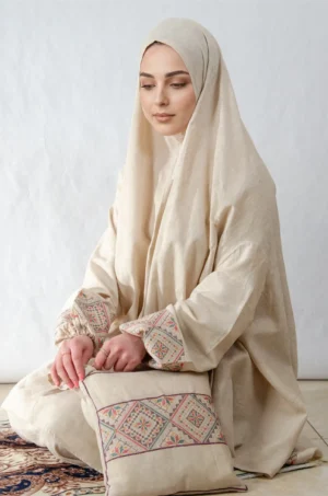 A beige 3-piece Khushoo embroidered prayer set featuring soft fabric and Fallahi embroidery inspired by handcrafted tradition. Designed for serene, elegant prayer moments.