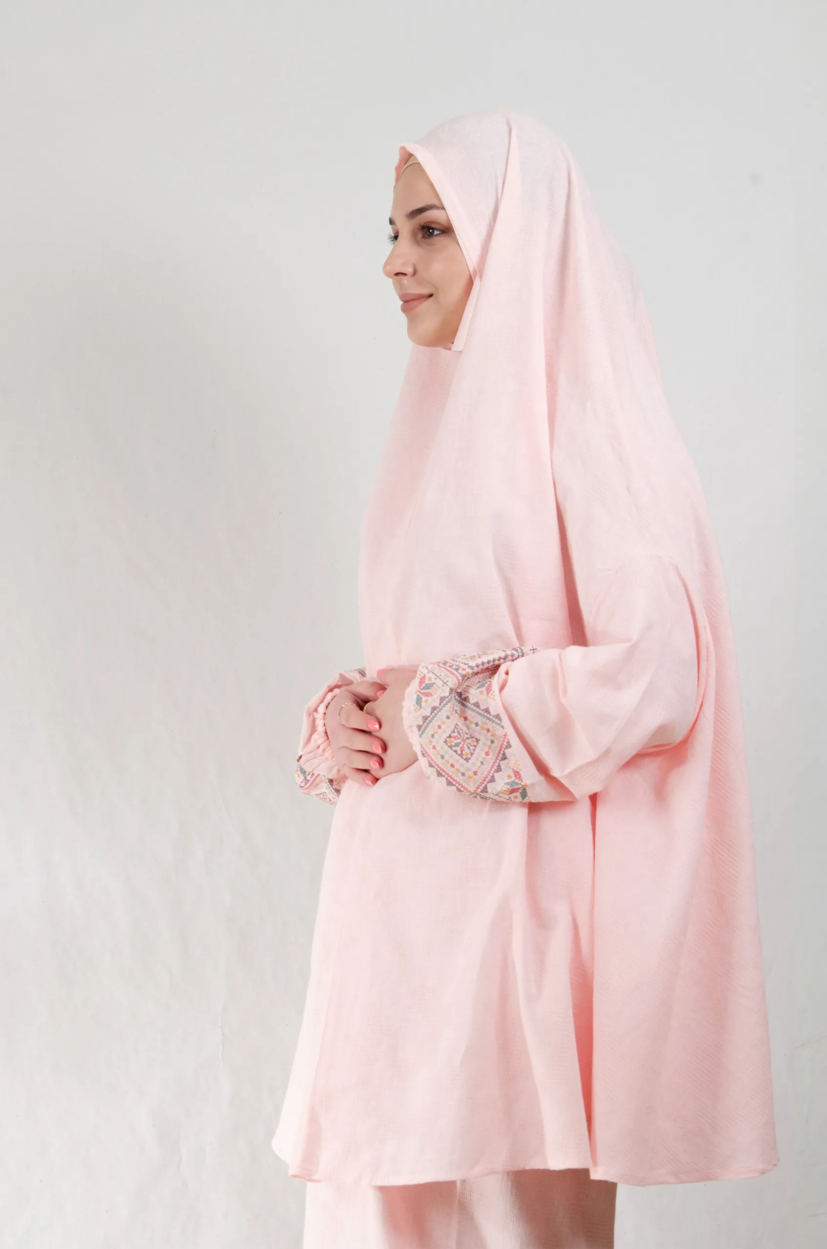 A pink 3-piece Khushoo embroidered prayer set featuring soft fabric and Fallahi embroidery inspired by handcrafted tradition. Designed for serene, elegant prayer moments.