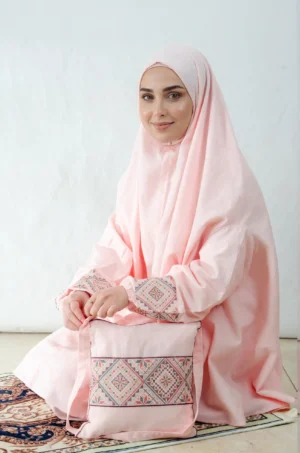 A pink 3-piece Khushoo embroidered prayer set featuring soft fabric and Fallahi embroidery inspired by handcrafted tradition. Designed for serene, elegant prayer moments.