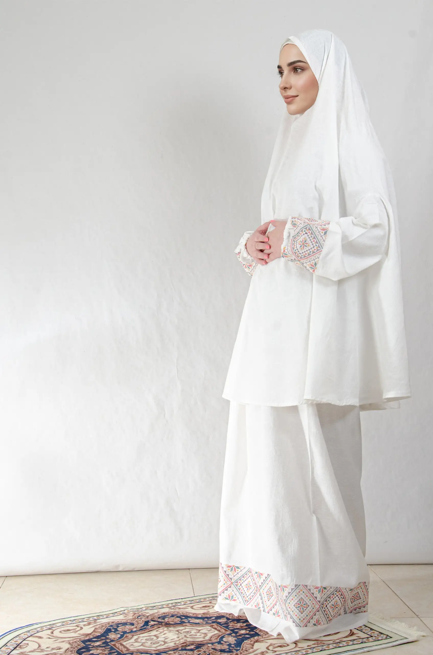 A white 3-piece Khushoo embroidered prayer set featuring soft fabric and Fallahi embroidery inspired by handcrafted tradition. Designed for serene, elegant prayer moments.