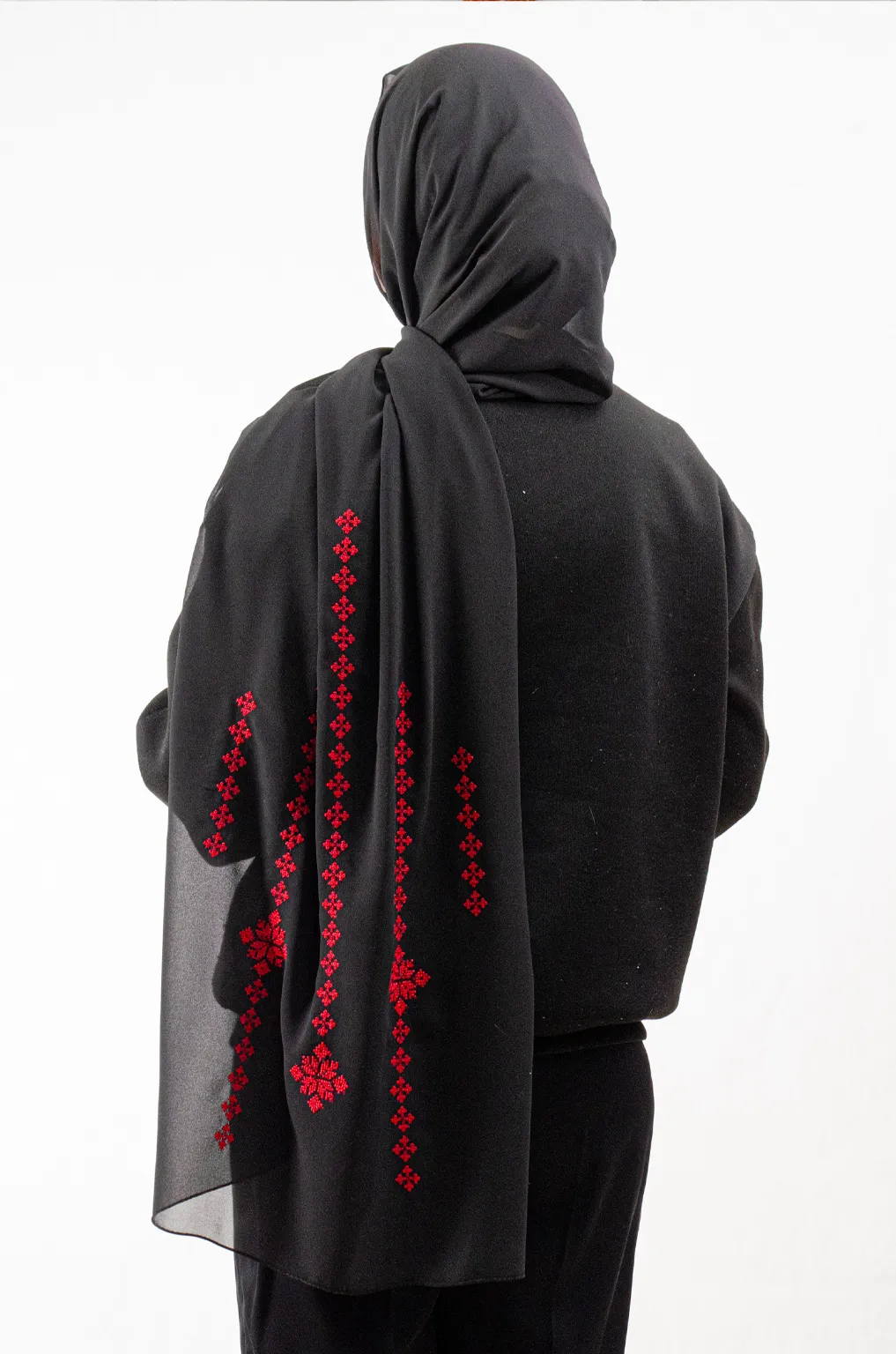 The Black-Red Taif Embroidered Shawl features bold red fallahi embroidery on a classic black chiffon base with refined aghabani detailing. This embroidered shawl offers graceful movement and versatile styling while celebrating the heritage of Palestinian تطريز.