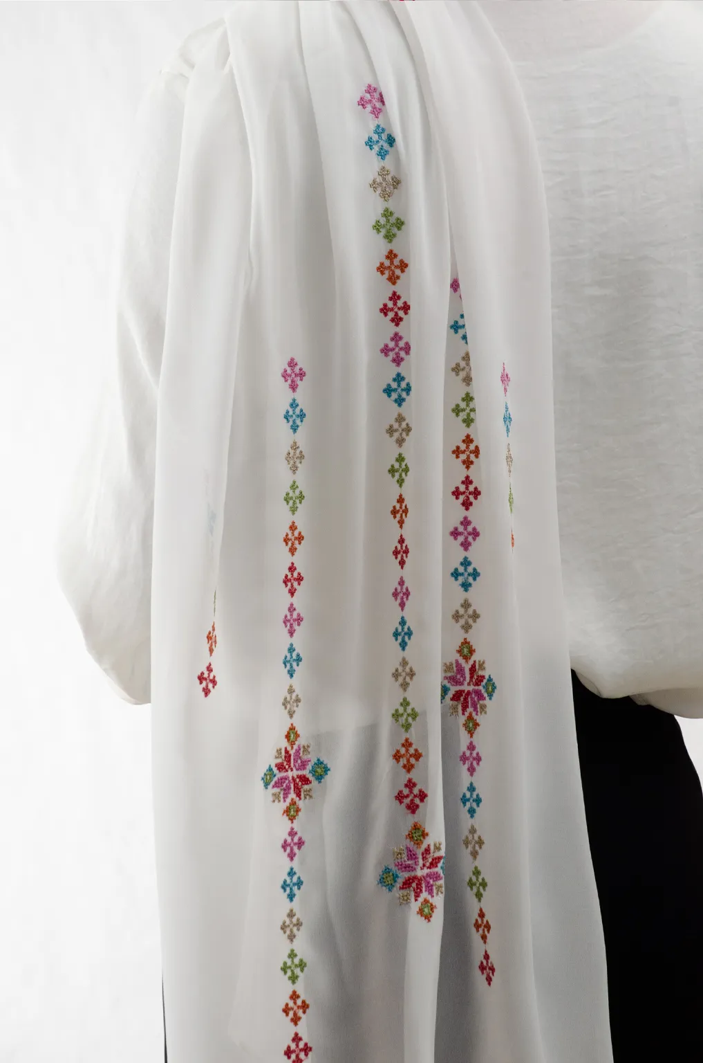 The Cream-Mix Taif Embroidered Shawl features traditional fallahi embroidery in mixed colors on a soft cream chiffon base with refined aghabani detailing. This embroidered shawl offers graceful movement and versatile styling while celebrating the beauty of Palestinian تطريز.