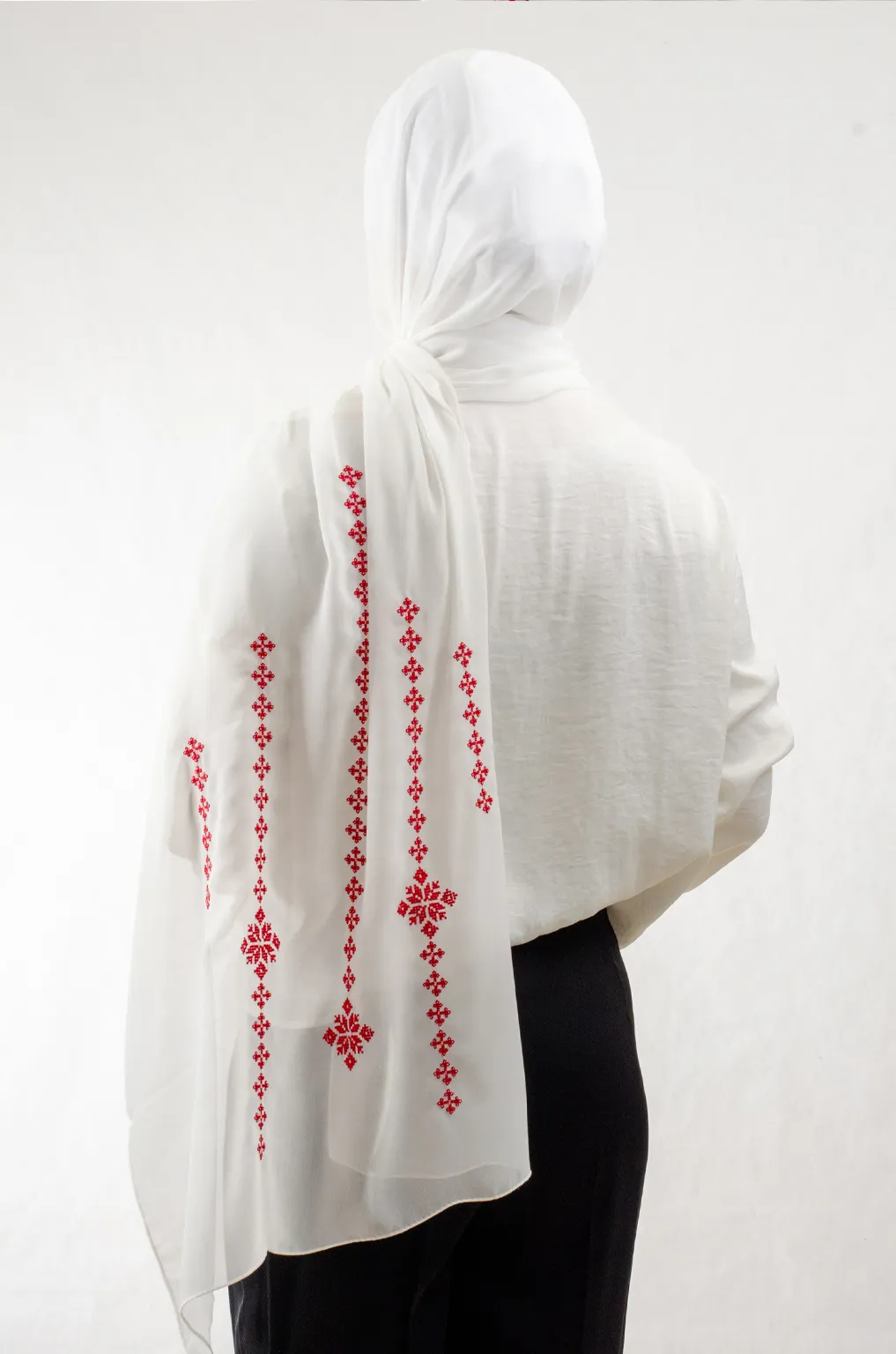 The Cream-Red Taif Embroidered Shawl features elegant red fallahi embroidery on a soft cream chiffon base with refined aghabani detailing. This embroidered shawl offers graceful movement and versatile styling while celebrating the beauty of Palestinian تطريز.