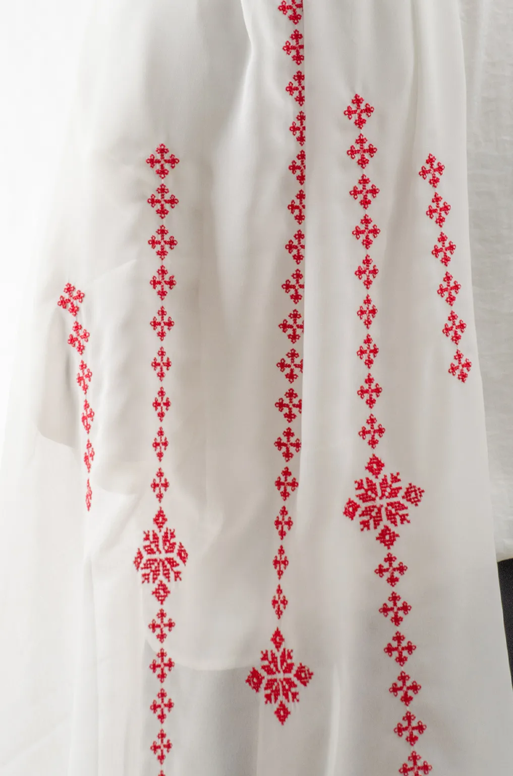 The Cream-Red Taif Embroidered Shawl features elegant red fallahi embroidery on a soft cream chiffon base with refined aghabani detailing. This embroidered shawl offers graceful movement and versatile styling while celebrating the beauty of Palestinian تطريز.