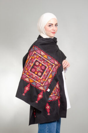 Model wearing black Tahreereh Falahi Mix shoulder shawl with red, pink, yellow and teal floral medallion embroidery