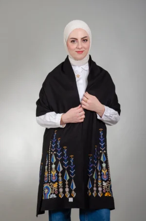 عارضة ترتدي شال كتف الساعة مع السرو نيلي فستقي أسود بتطريز السرو بالأزرق واللافندر والأخضر المريمية