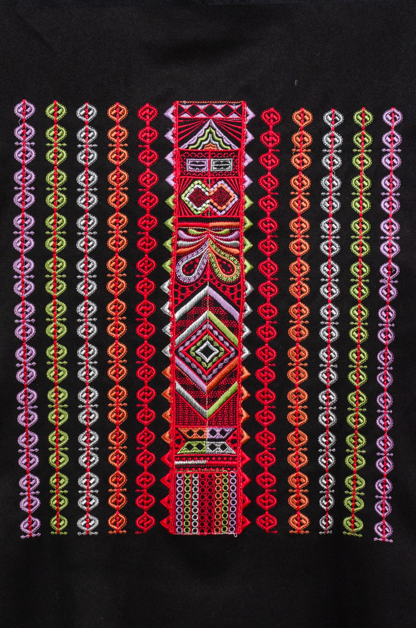 Close-up of red, lime green and lilac Al-Shamal Bratto embroidery on black shoulder shawl